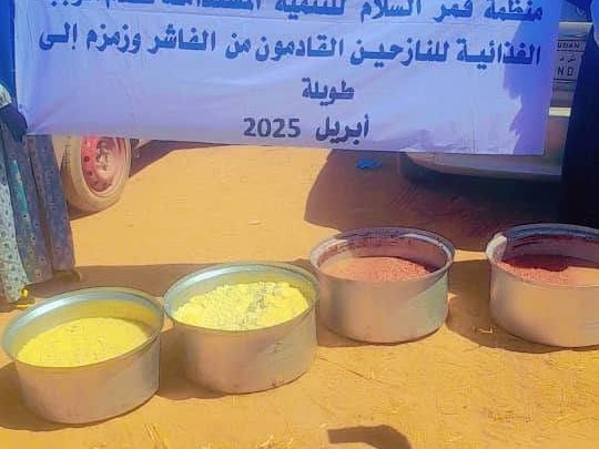 Pots of cooked food in front of the organisation's banner in Tawila, April 2025
