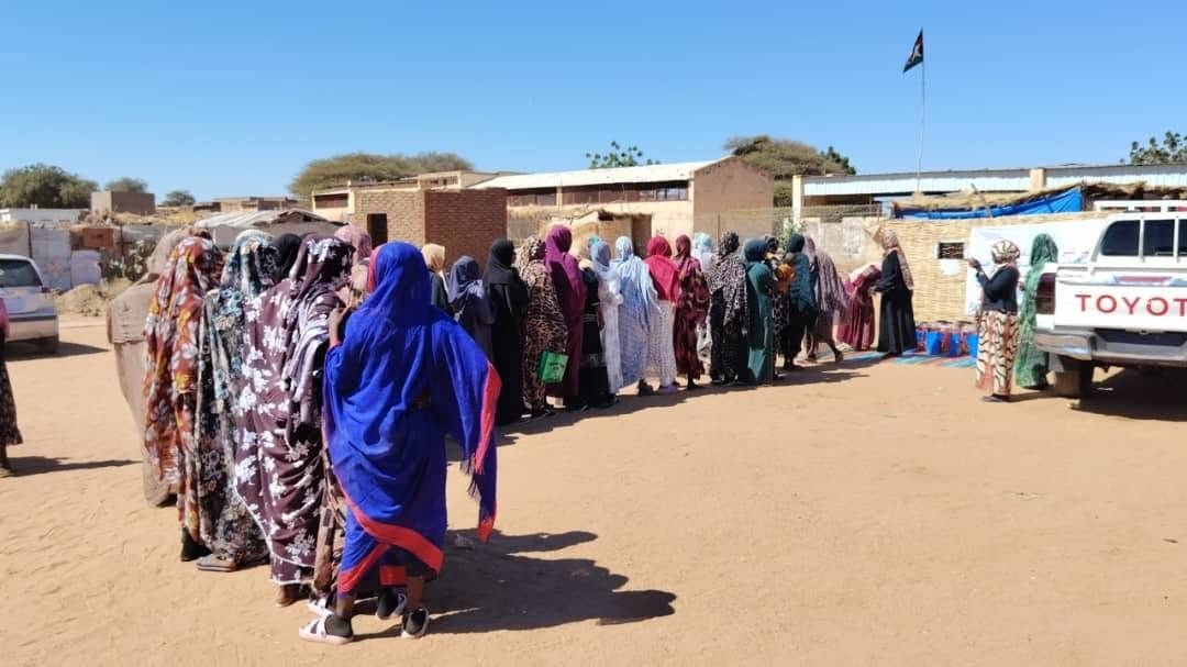 Displaced women wait in line at a distribution in Tawila, 2026